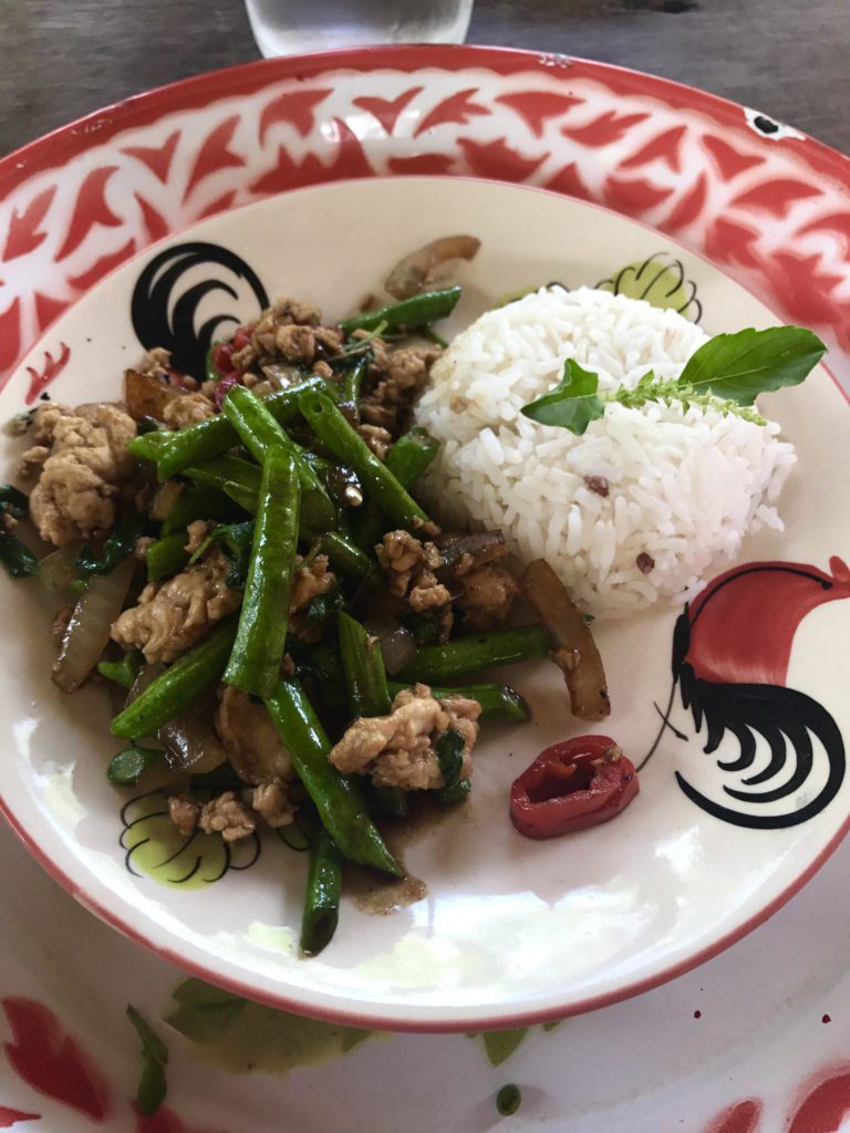 A plate with stir fry chicken and white rice