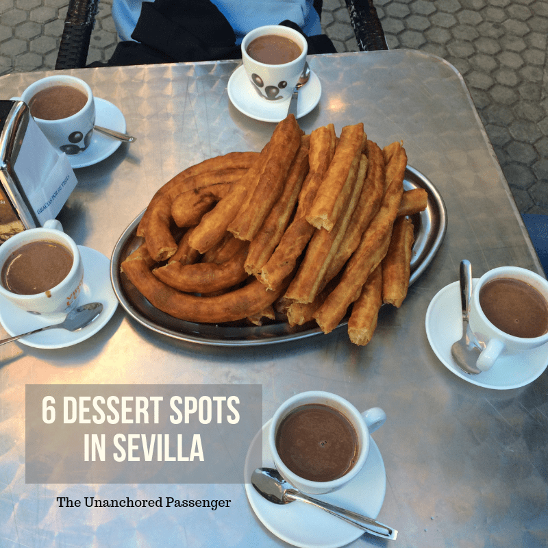 Churros on a plate with mugs of chocolate and text that reads "6 Dessert Spots in Sevilla" and "The Unanchored Passenger"