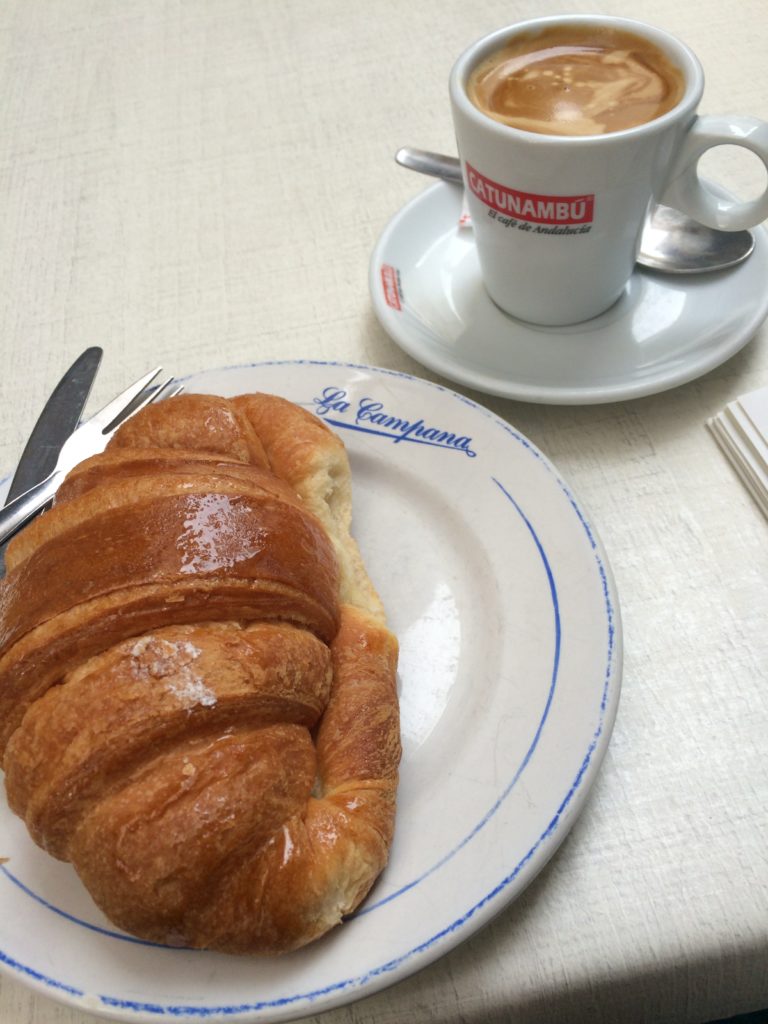 Croissant on a plate and a mug filled with coffee