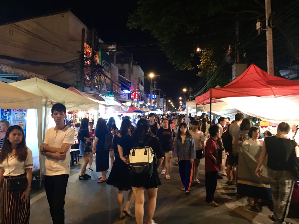 People walking around a street market in Thailand