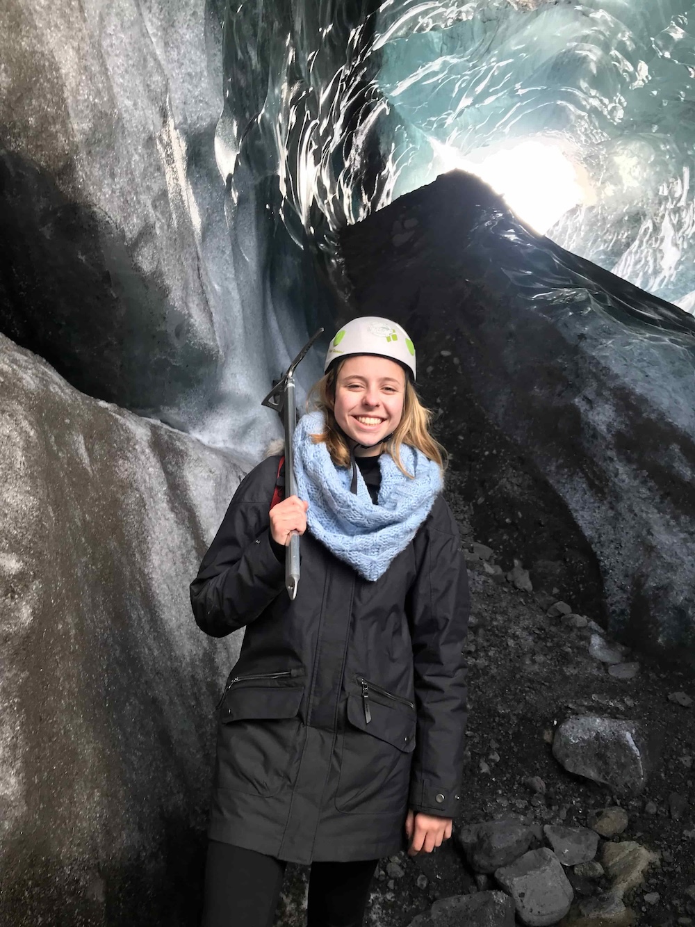 Woman smiling in an ice cave on a glacier hike in Iceland in March