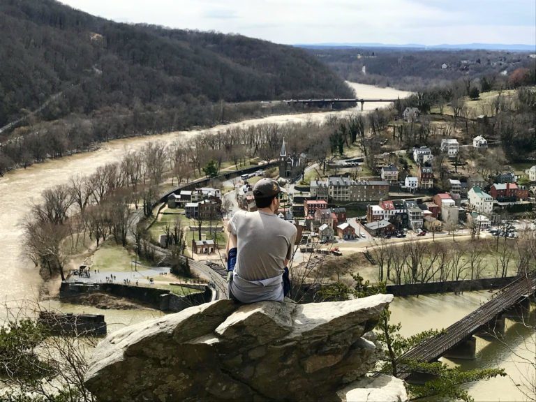 Man sitting on a rock at an overlook of Harpers Ferry