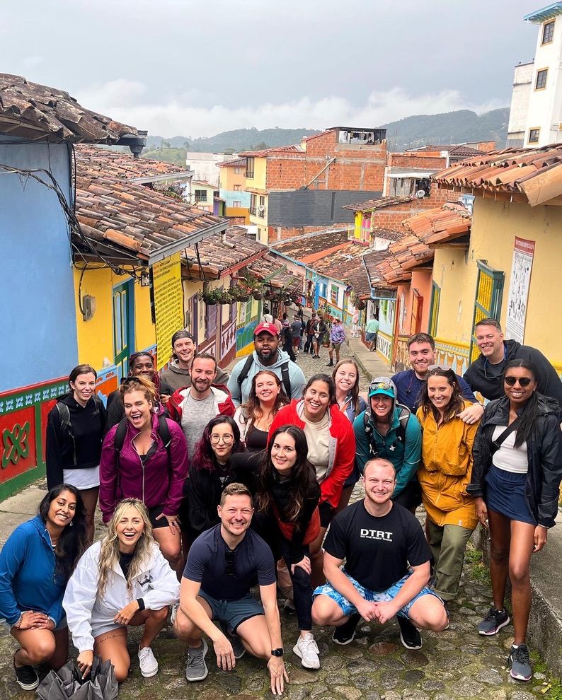 A group of people on a colorful street in Guatapé, Colombia