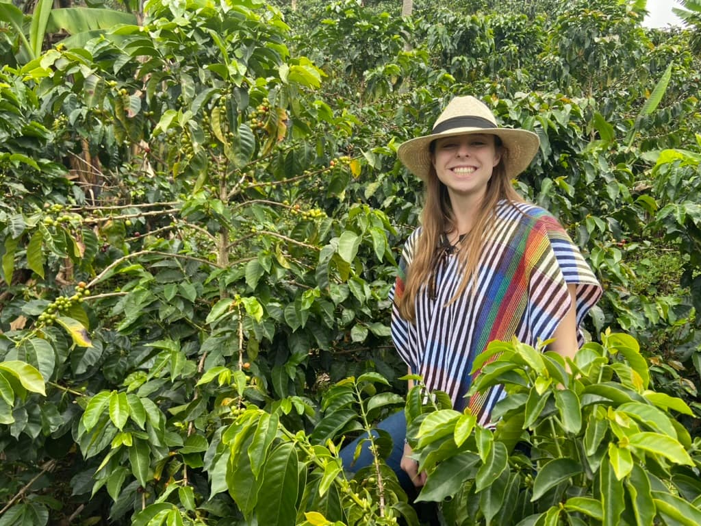 Woman smiling at a coffee farm in Colombia