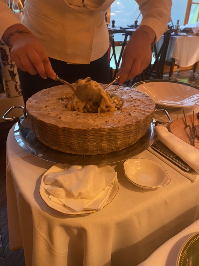 Stirring pasta in a wheel of parmesan cheese before serving for dinner at Rocco in Lisbon, Portugal