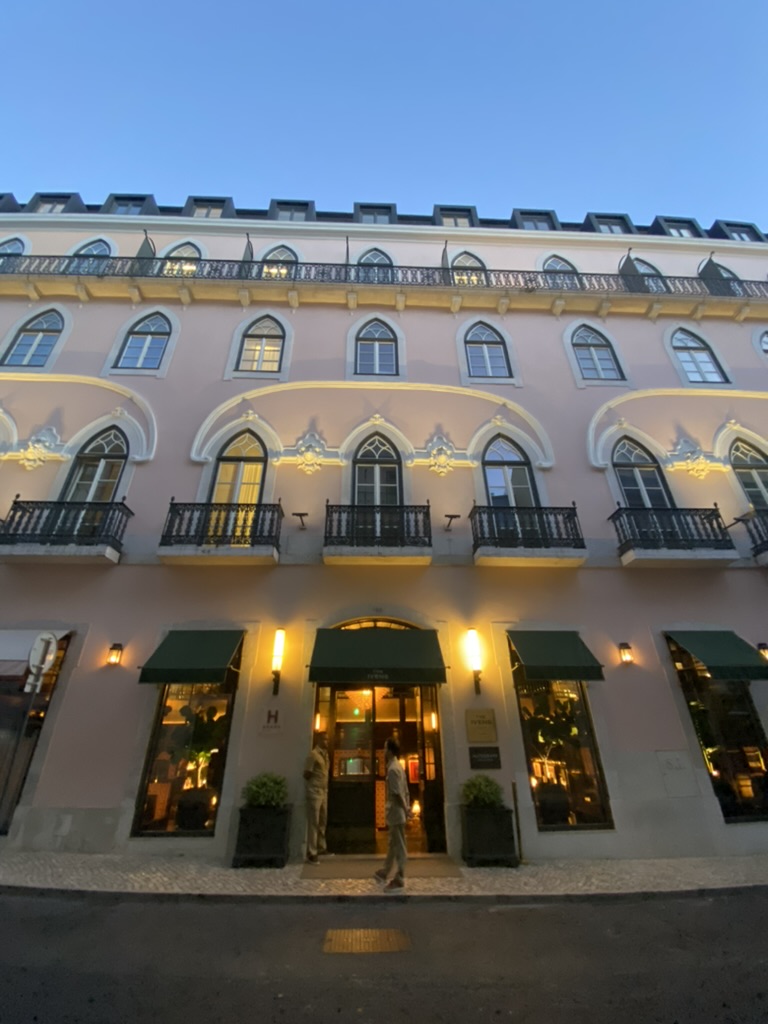 The Ivens Hotel in Lisbon, a large pink building lit up at night