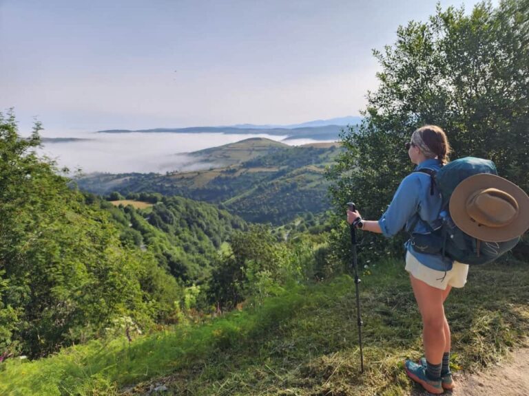 Female hiker looking down over a mountain valley below