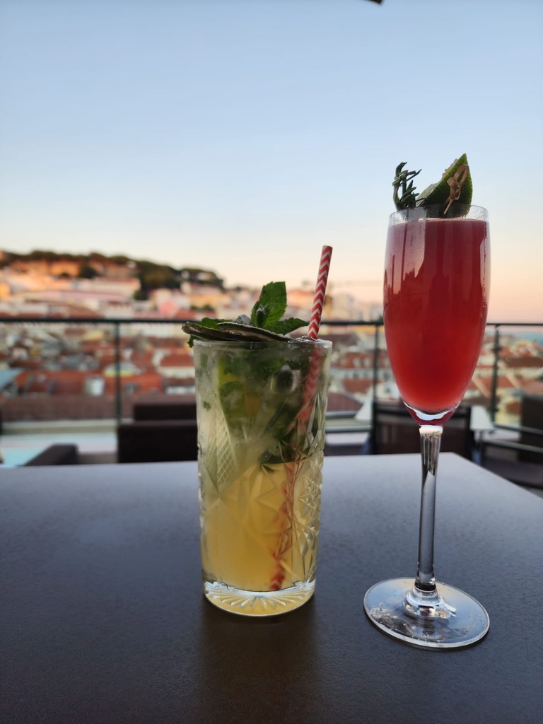 Two drinks at Entretanto Rooftop Bar looking out over the city of Lisbon, Portugal