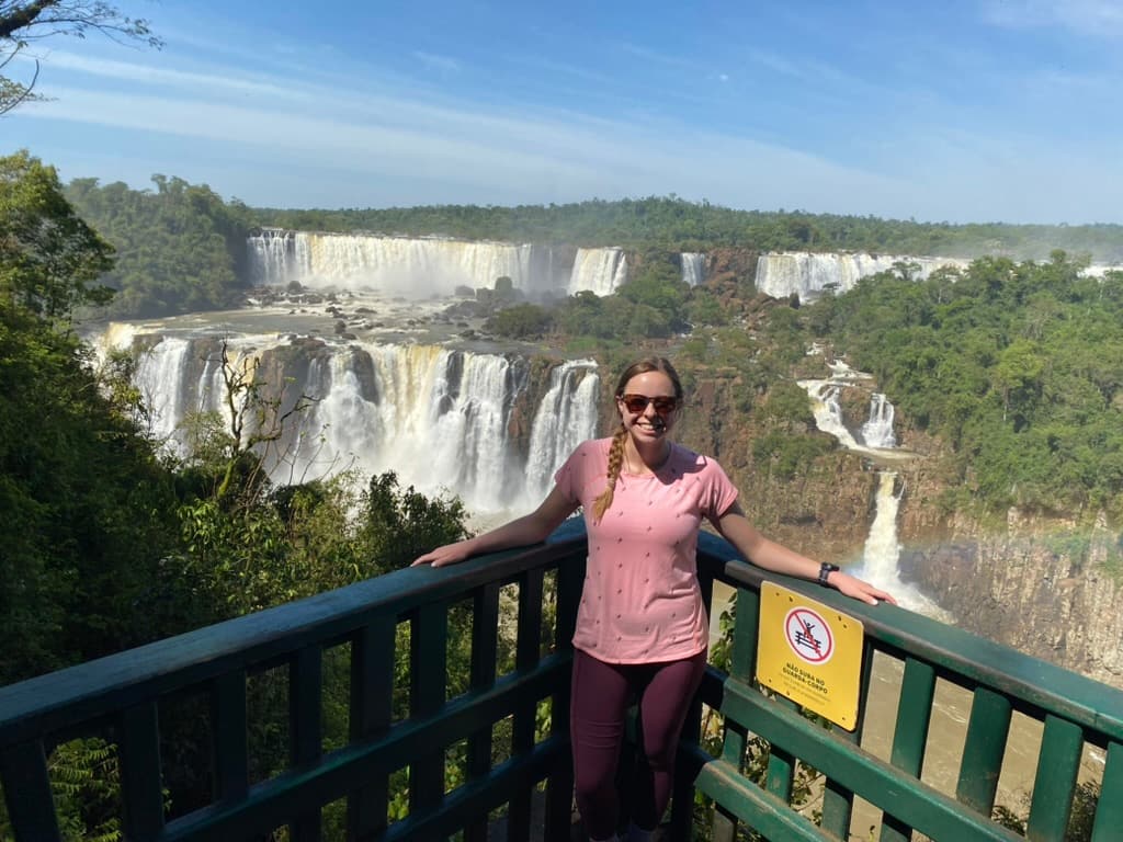 Woman smiling at lookout point with Iguazu Falls in the background