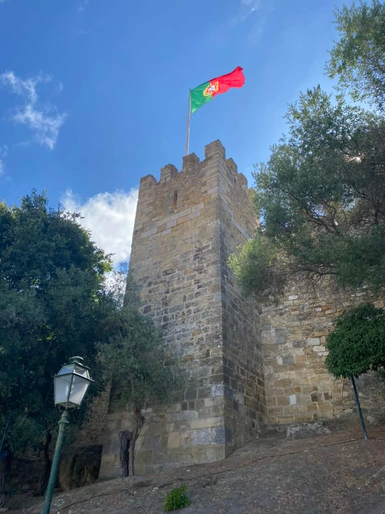 Tower of Castelo de São Jorge in Lisbon, Portugal with the Portuguese flag flying from its top