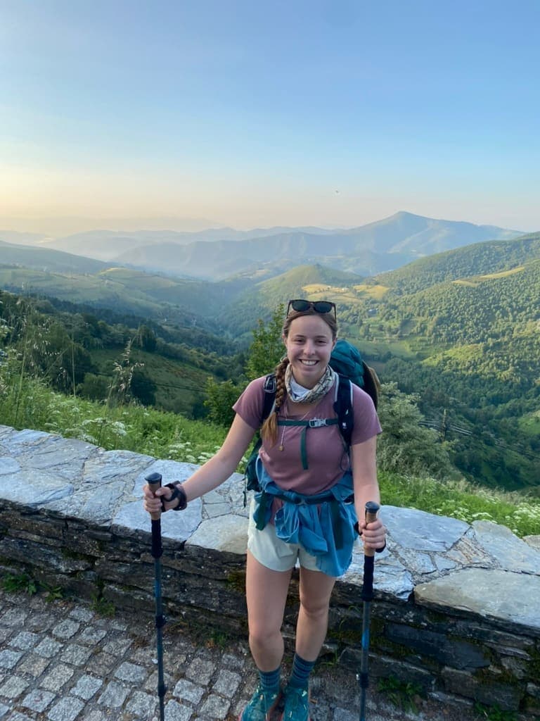 Female hiker smiling with mountains in the background