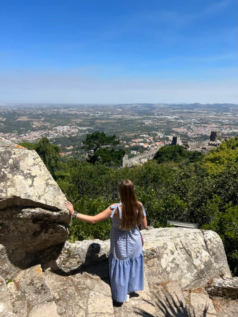 Woman looking out over the castle walls at the Castle of the Moors in Sintra, Portugal