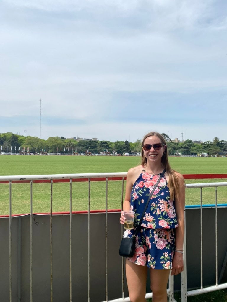 Woman smiling in front of a field at a polo match in Buenos Aires