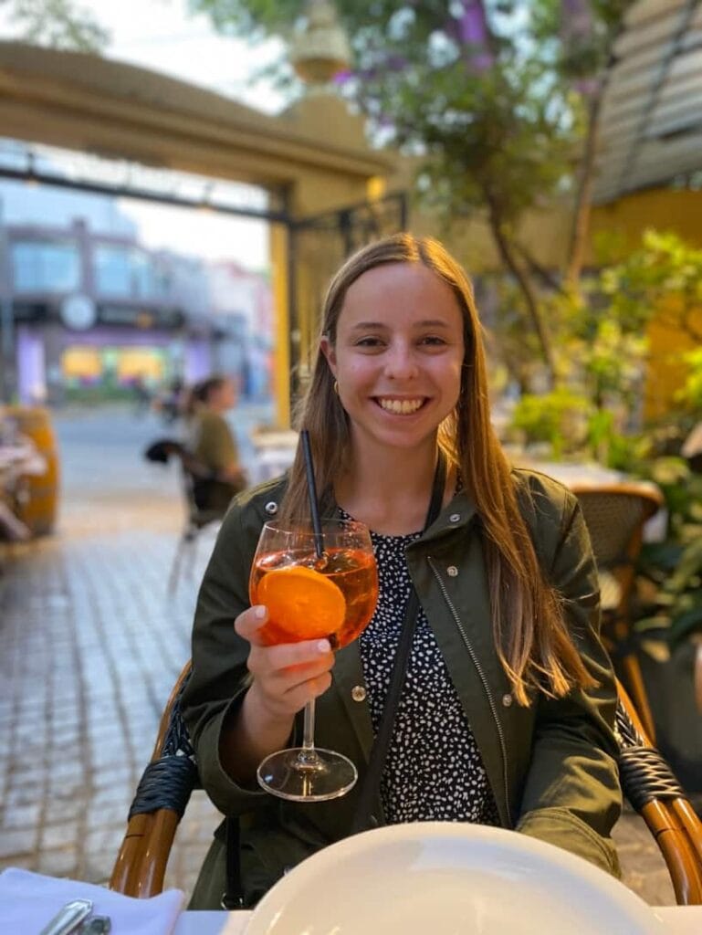 Smiling woman holding an Aperol spritz