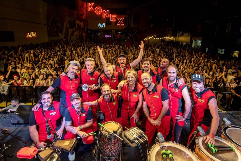 Group of drummers smiling with the crowd in the background at La Bomba de Tiempo in Argentina