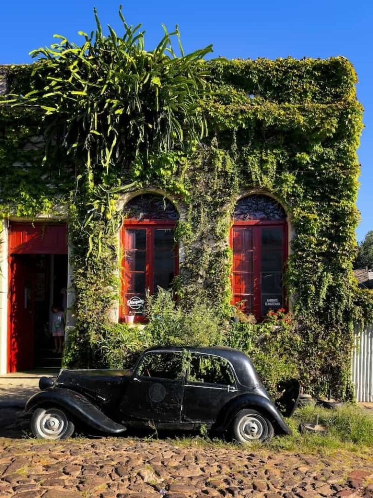 An ivy covered building and old car in Colona del Sacramento, Uruguay