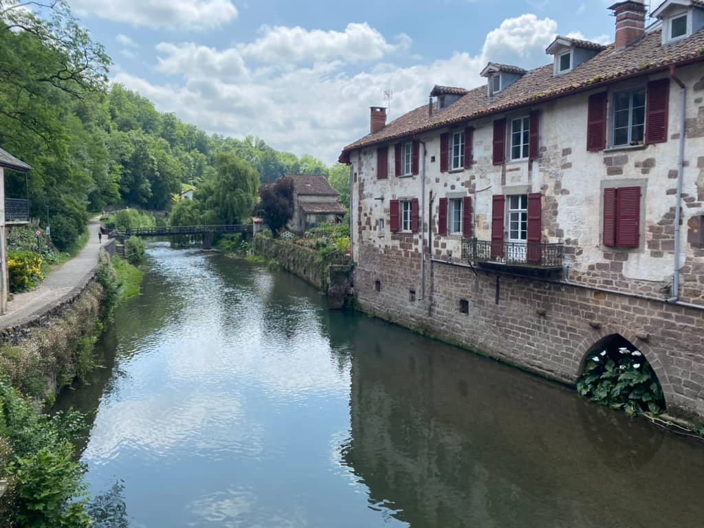 River running through Saint-Jean-Pied-de-Port with a historic building next to it.