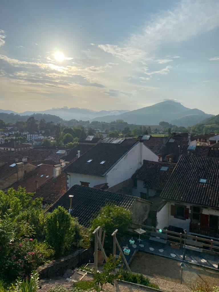 View from above of the Pyrenees Mountains in the distance and buildings below in Saint-Jean-Pied-de-Port.