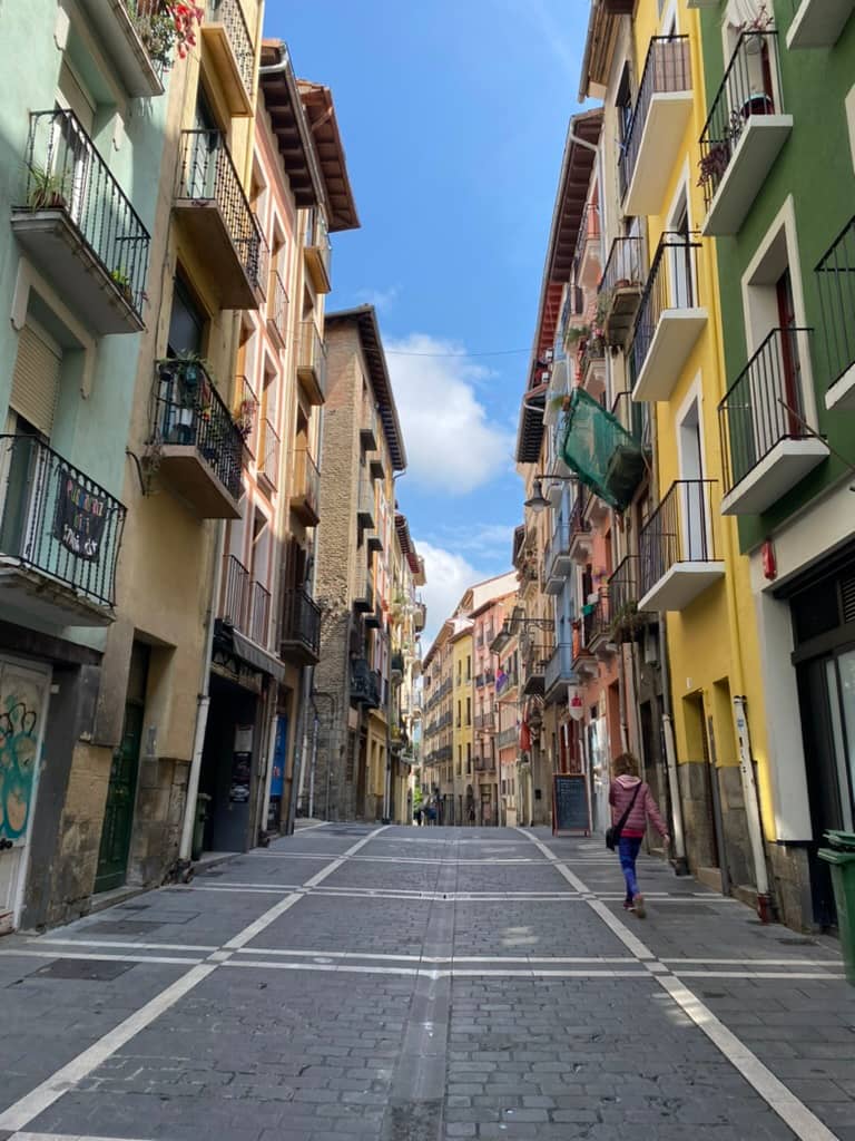 Narrow streets lined with colorful buildings in Pamplona's old town.