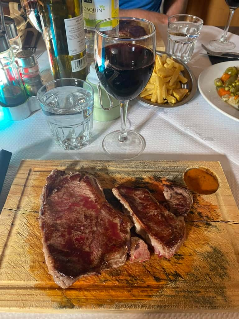 Steak and wine at dinner at an albergue in Gonzar, Spain.