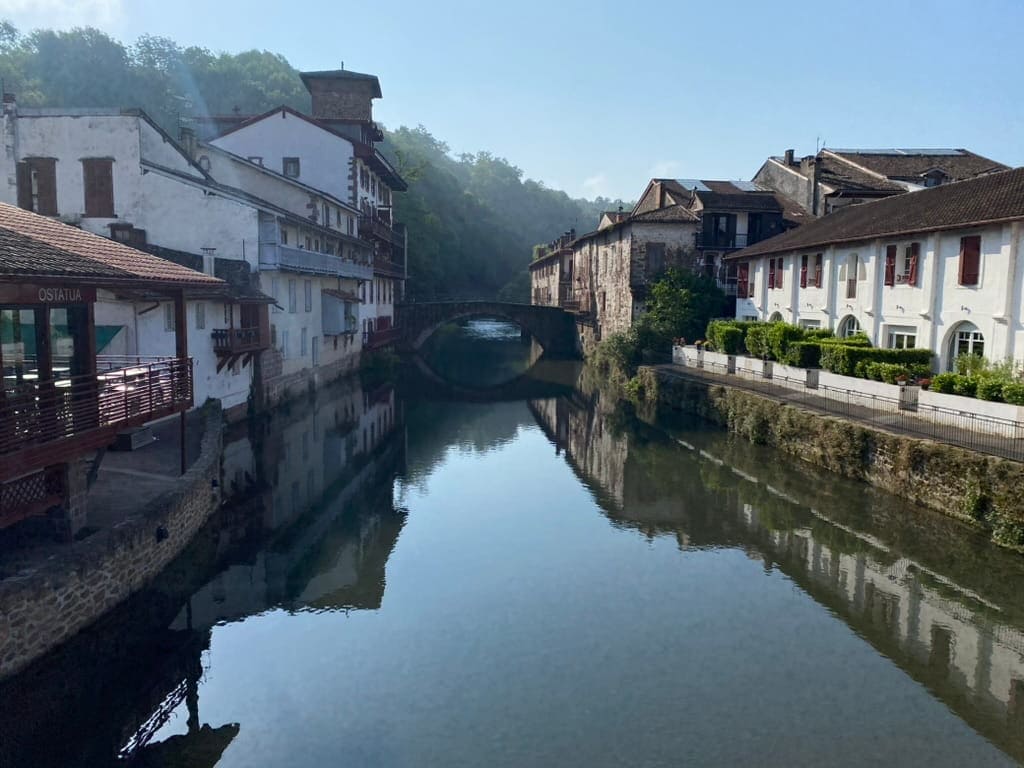 River running through Saint-Jean-Pied-de-Port with a bridge over it and historic charming buildings around