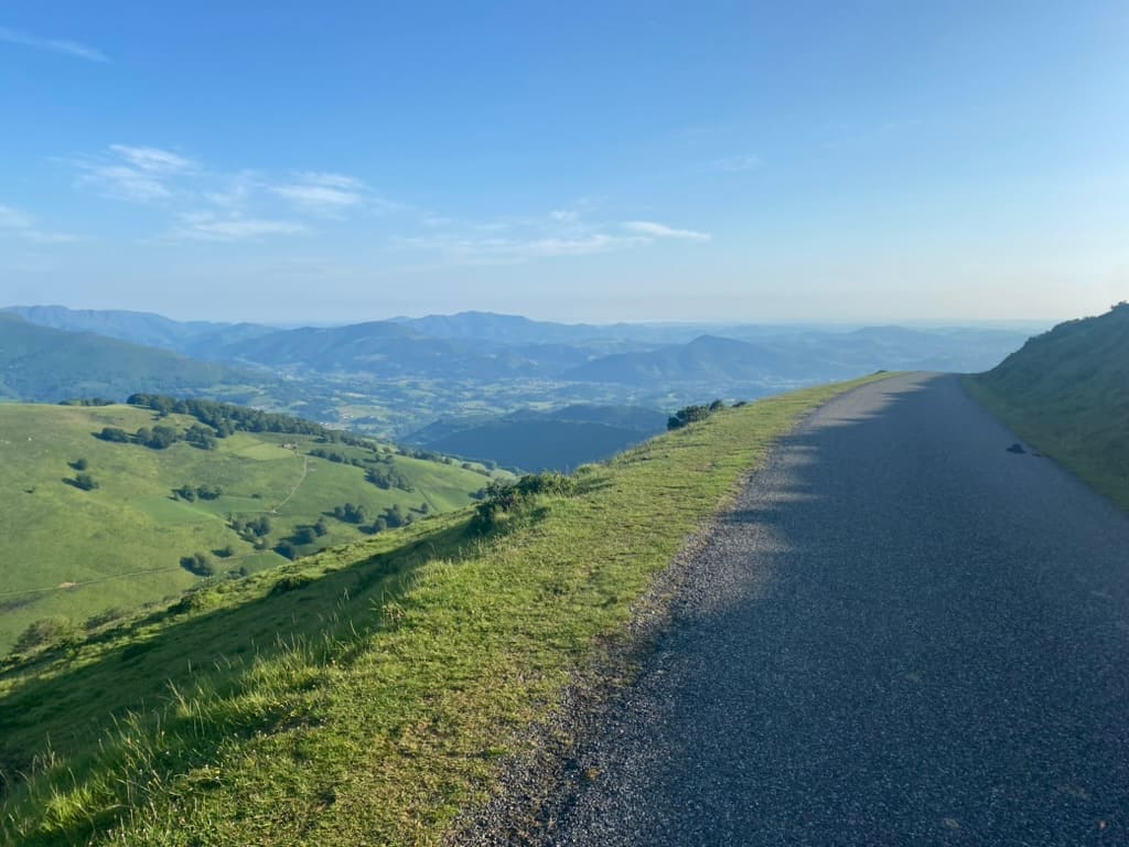 Path along the Camino Francés through the Pyrenees Mountains with lush green mountain views in the distance.